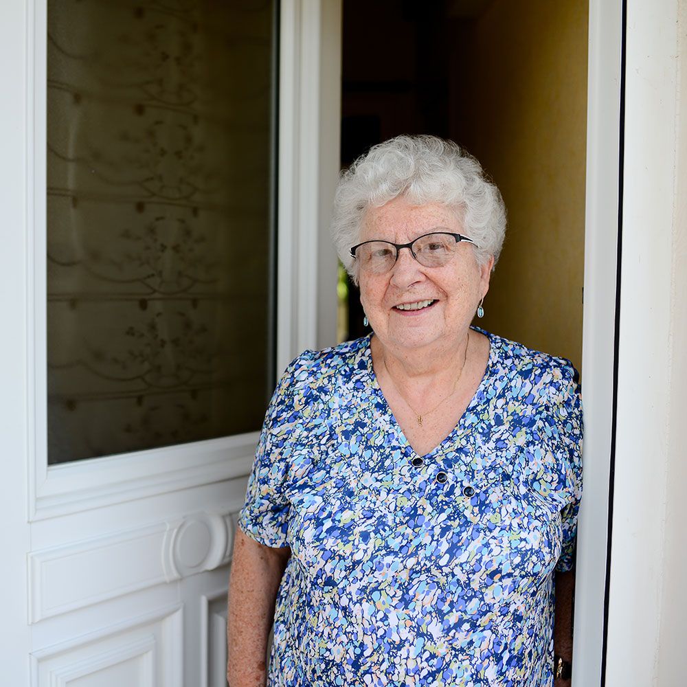 Ältere Person steht vor einer offenen Tür